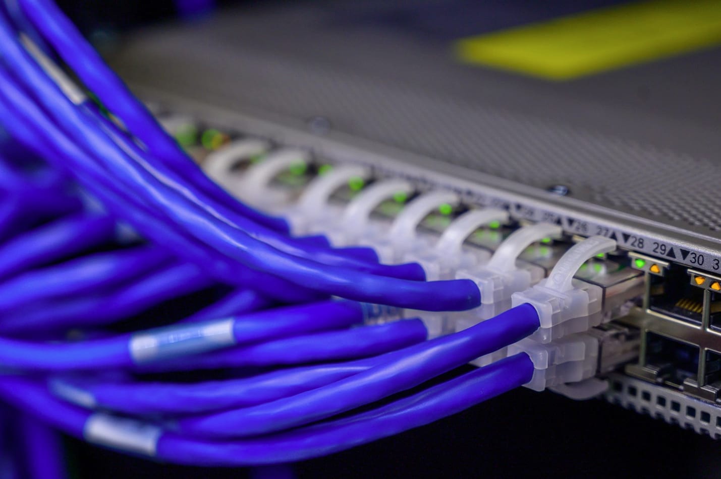 Portas de um switch de rede com cabos ethernet conectados